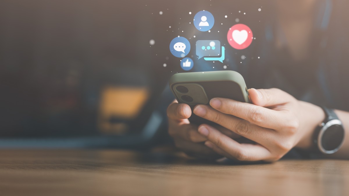 ソーシャルメディアとデジタルオンラインのコンセプト。自宅のソファでスマートフォンを使う女性。休暇中にソーシャルメディアを楽しむというコンセプト。