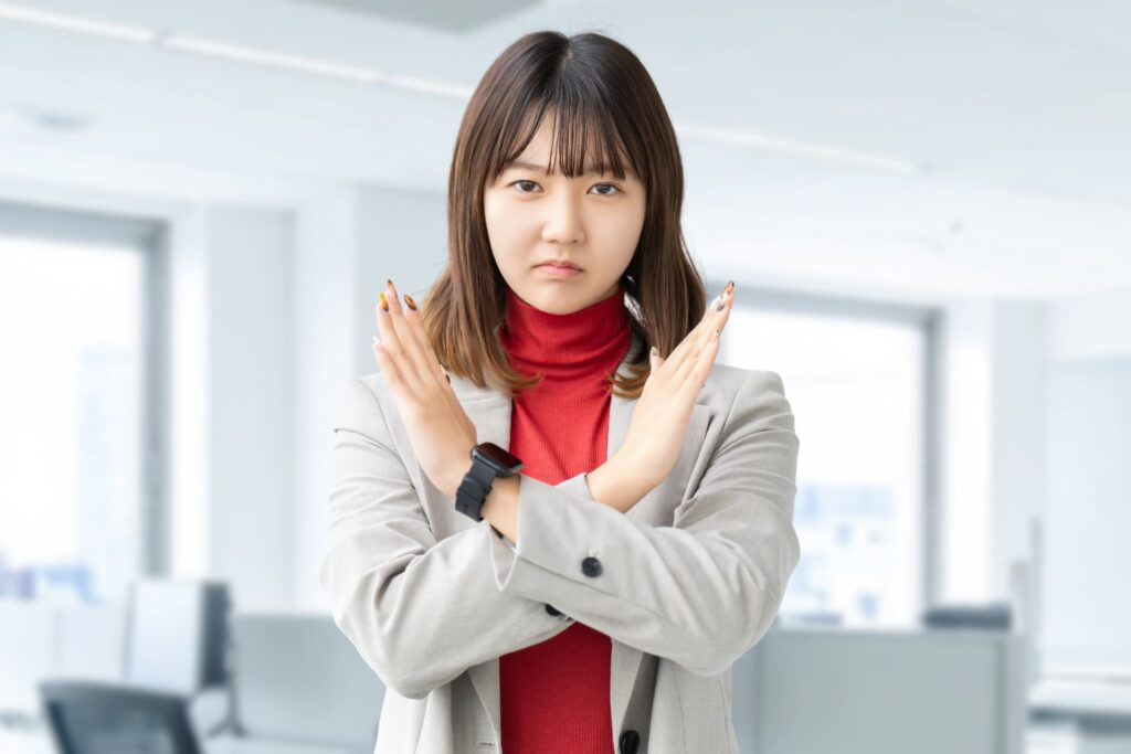 ばつマークを作る女性