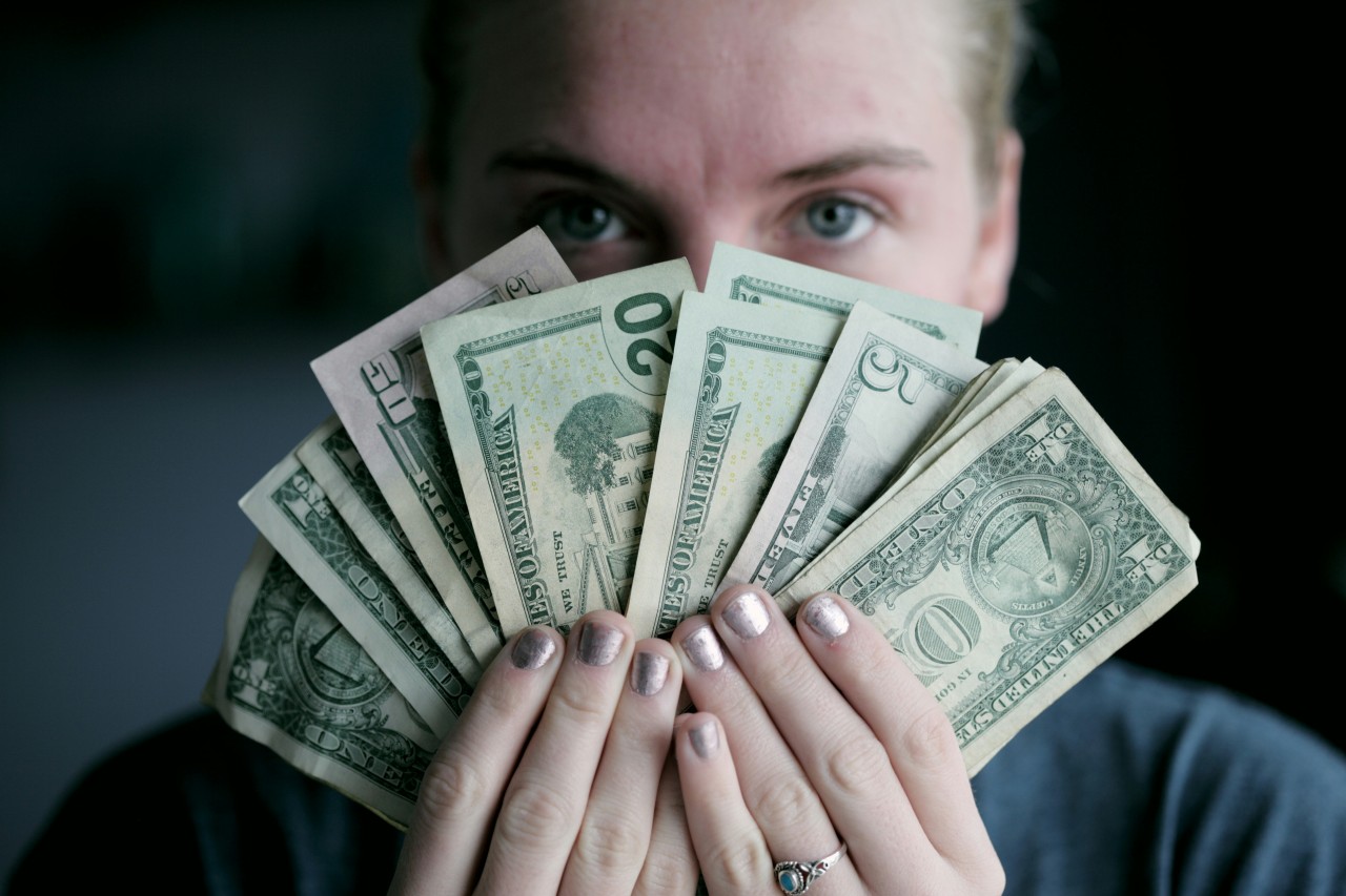 お金を見せる女性