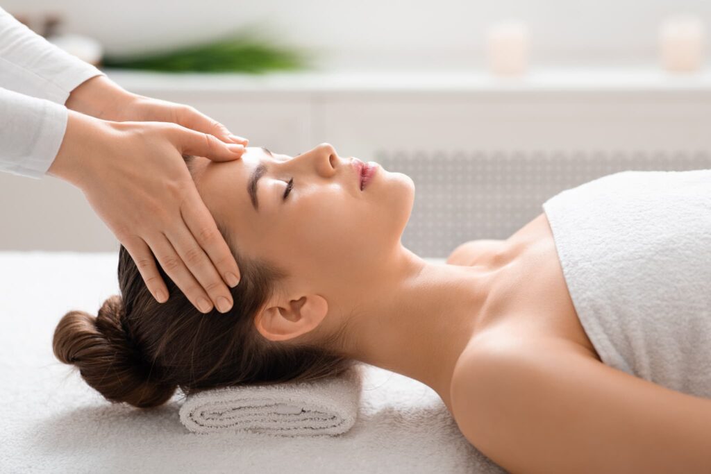 Young woman getting relaxing head massage at spa